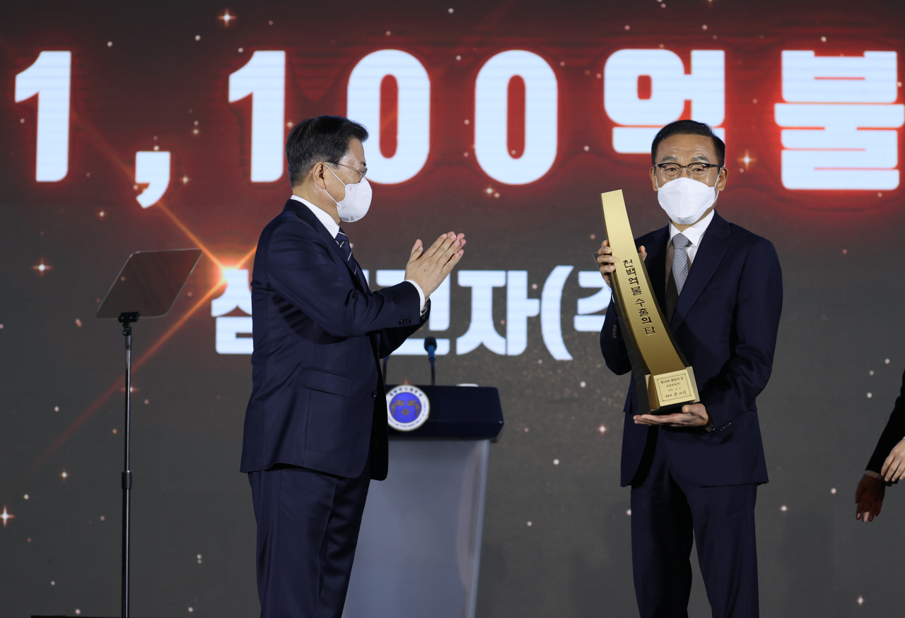 Samsung Electronics Chief Executive Officer Kim Ki-nam (right) pose for a photo with President Moon Jae-in (fourth from left) during a Tower of Export awarding ceremony held at Coex in Seoul on Monday. (Yonhap)