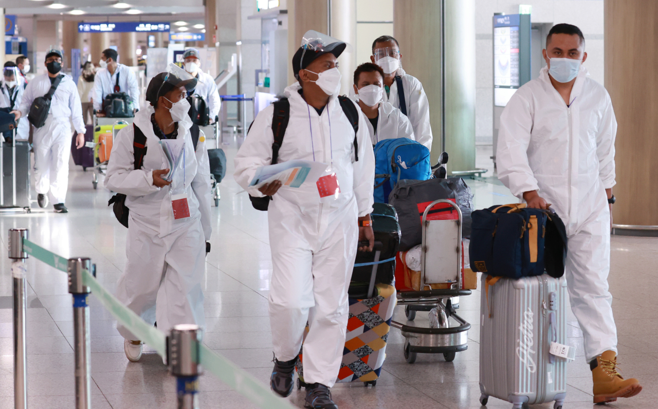 Foreign travelers arriving in protective clothing at Incheon Airport Terminal 1 on Monday morning are moved to quarantine facilities due to the spread of the omicron variant. (Yonhap)