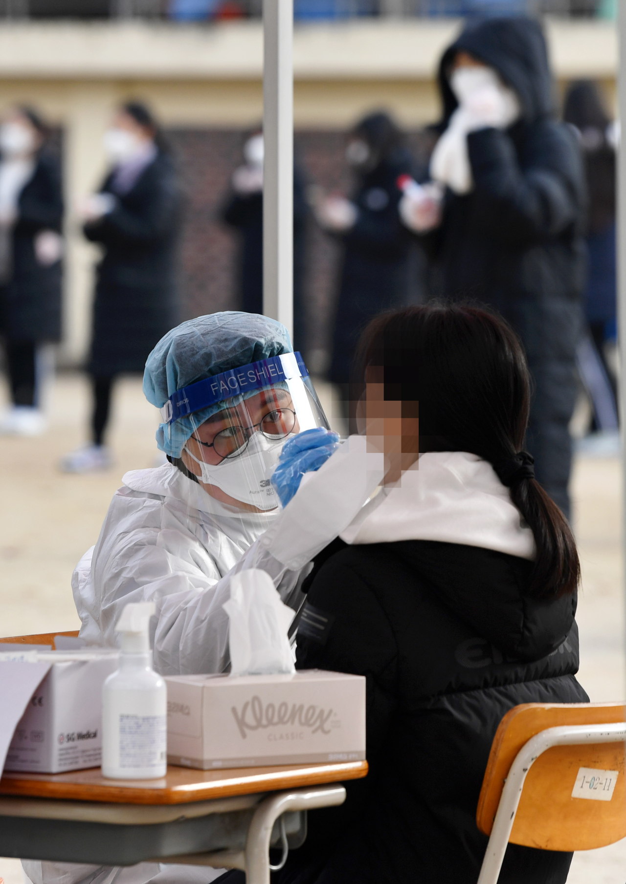 This file photo taken last Friday shows students receiving a COVID-19 test at a high school in the southwestern city of Gwangju. (Yonhap)