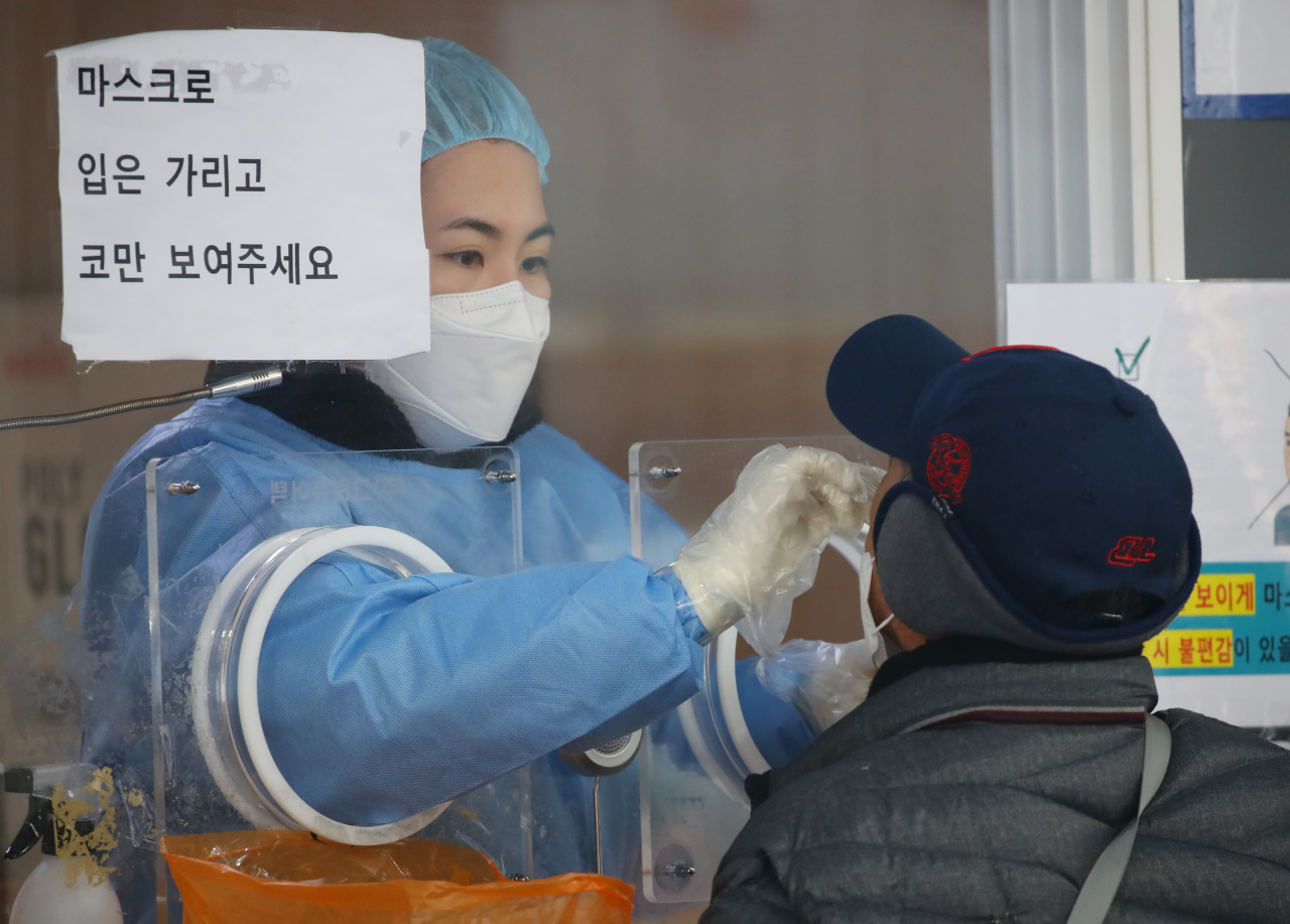 A man gets tested for the coronavirus in Incheon, west of Seoul, on Dec. 6, Monday. (Yonhap)