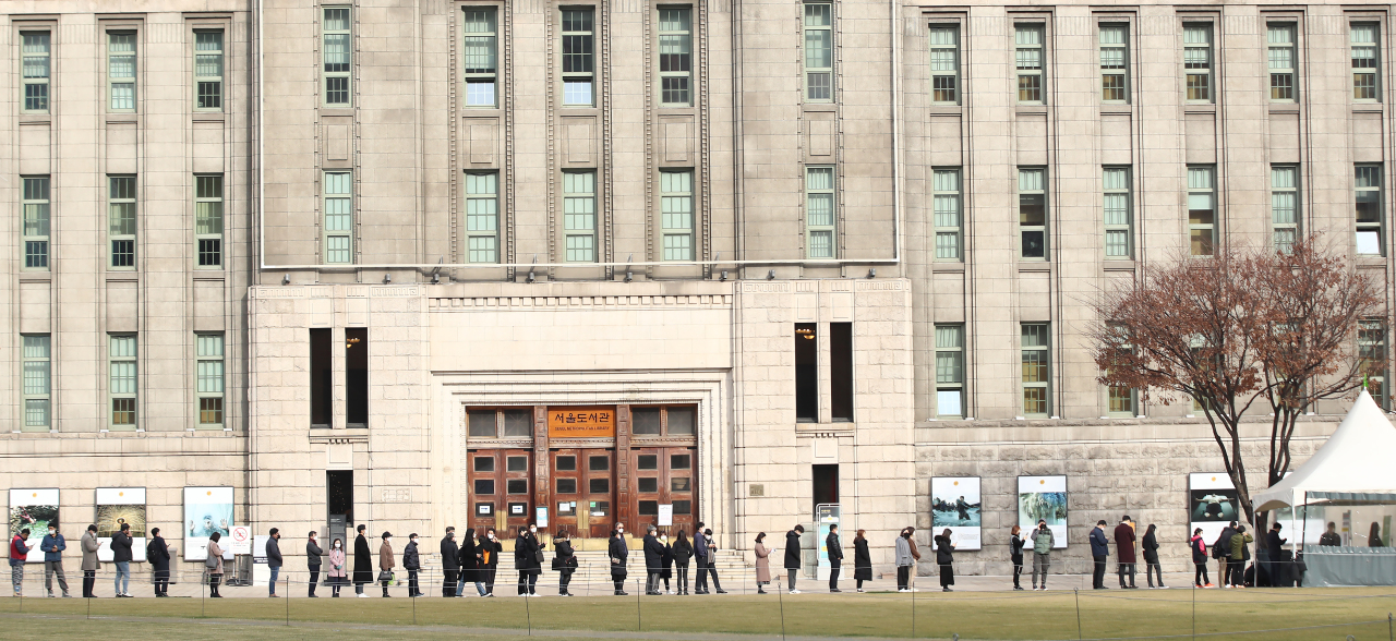 People wait in line to be tested of COVID-19 in front of the Seoul City Hall, Thursday. (Yonhap)