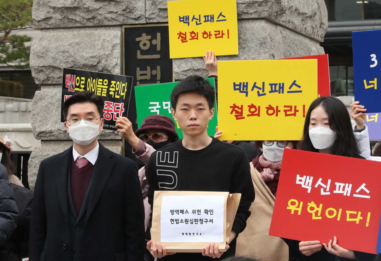 High school student Yang Dae-rim (C) arrives at the Constitutional Court in central Seoul on Friday, to submit a petition challenging the government's plan to expand the COVID-19 vaccine pass program to teenagers starting February. (Yonhap)