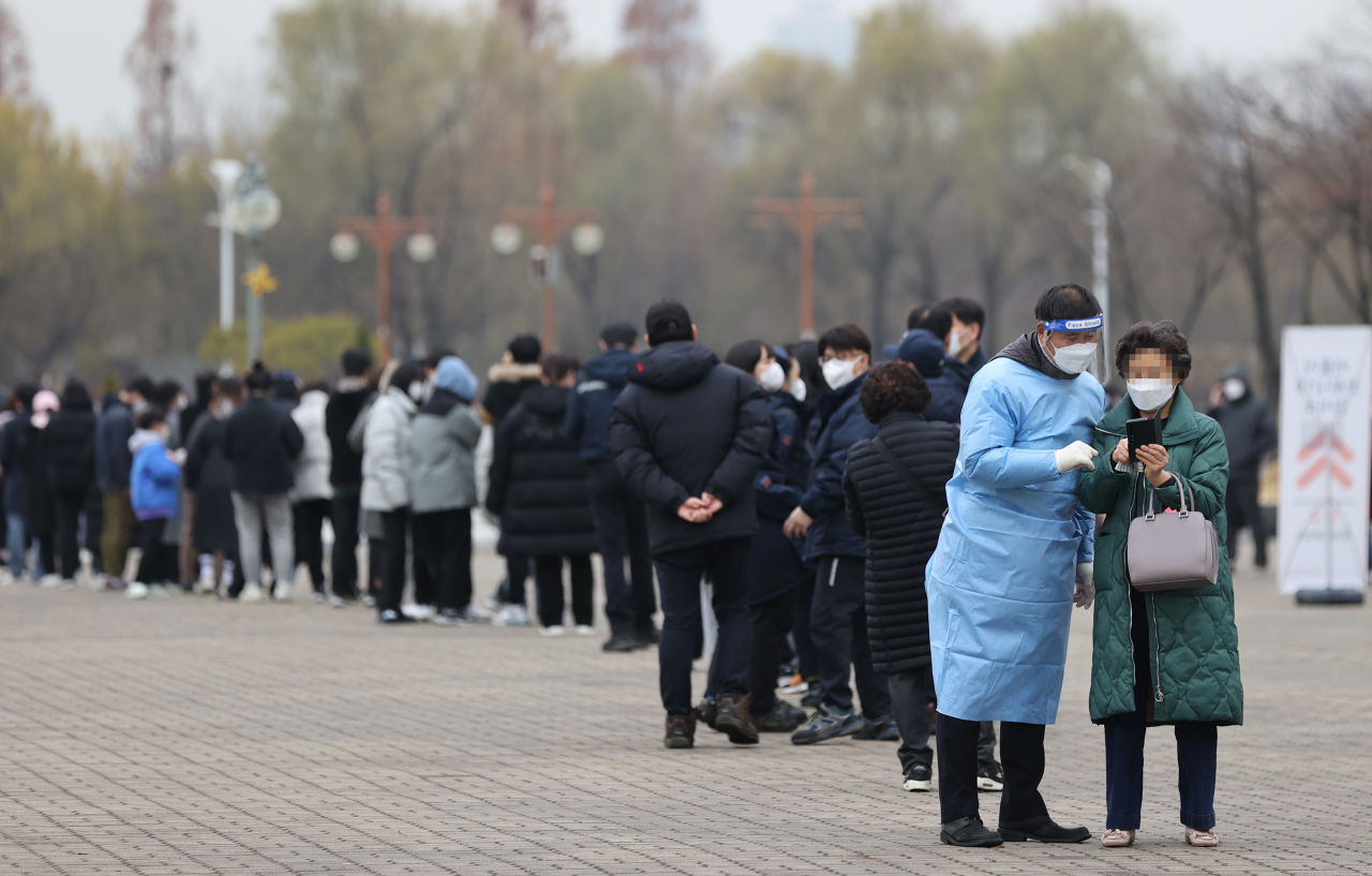 People line up in front of a COVID-19 testing center in Seoul, Friday. (Yonhap)