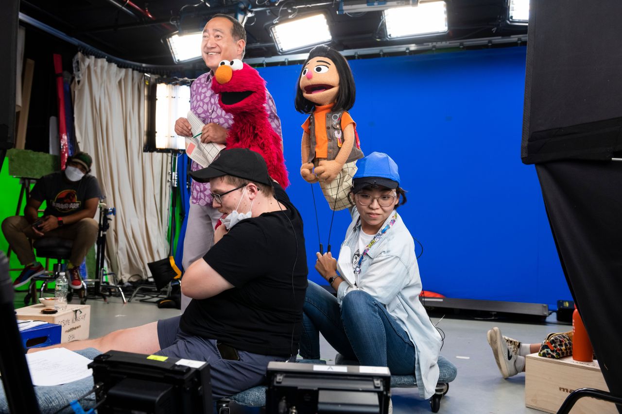 Kathleen Kim performing Ji Young alongside Alan Morauca, puppeteer Ryan Dillon and Elmo (c) Sesame Workshop by Zach Hyman