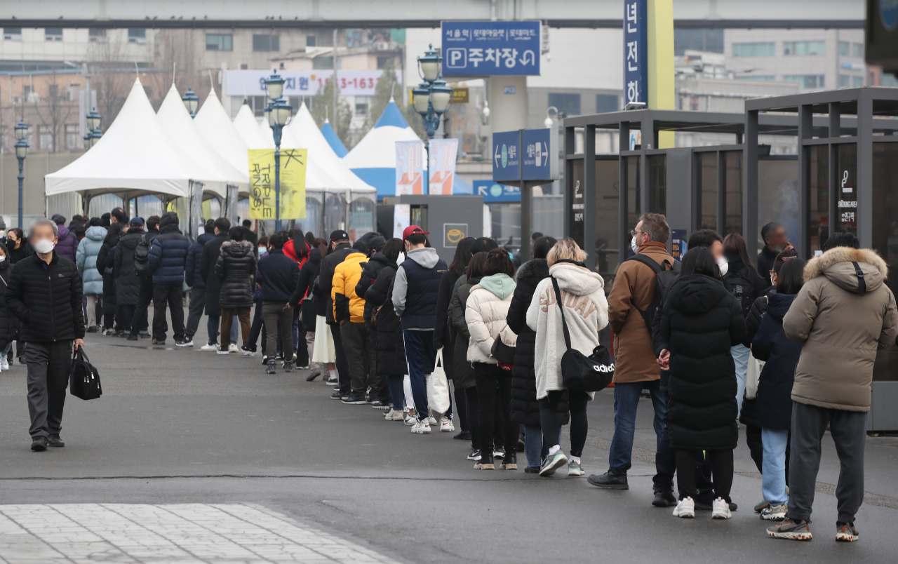 People stand in line to receive tests at a COVID-19 testing station in Seoul (Yonhap)