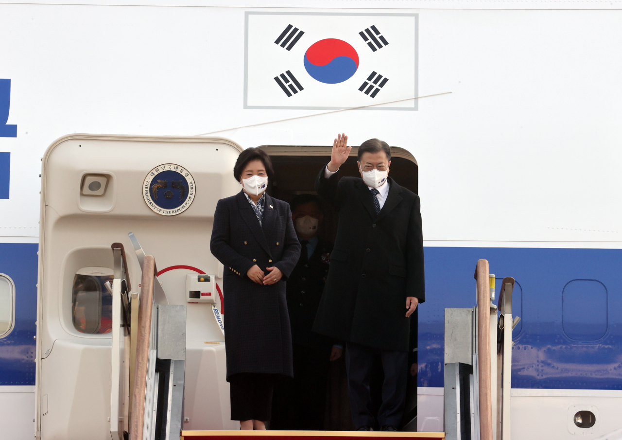 President Moon Jae-in and first lady Kim Jung-sook greet reporters as they board Air Force Unit 1 at Seongnam Seoul Airport on Sunday morning for a four-day state visit to Australia. (Yonhap)