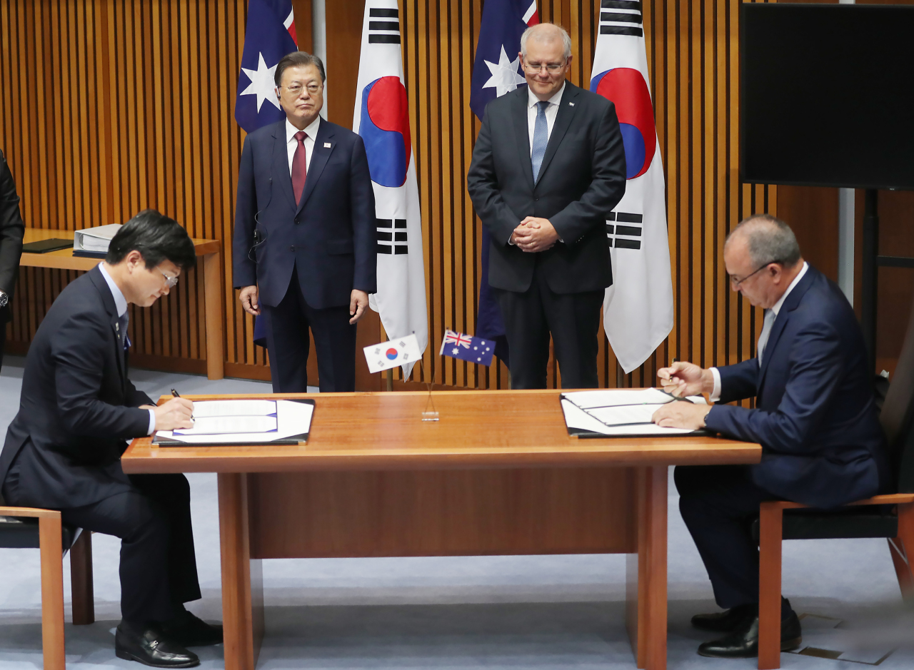 Kang Eun-ho (L), head of South Korea`s Defense Program Acquisition Administration, and his Australian counterpart, Tony Fraser, sign a memorandum of understanding on defense industry and material cooperation at the Parliament House in Canberra on Dec. 13. (Yonhap)