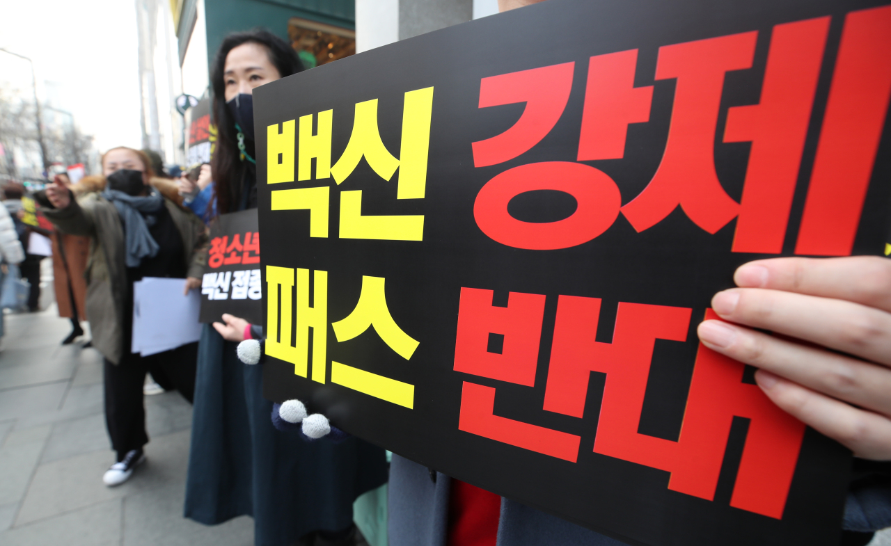 A civic group holds a protest against government’s plan to expand the vaccine pass system to teenagers aged between 12 and 18, near Sinnonhyeon Station in Gangnam, southern Seoul, Saturday. (Yonhap)
