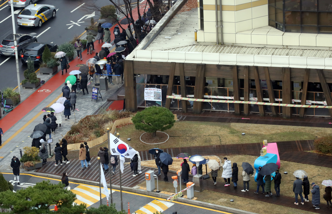 People stand in line to receive tests at a COVID-19 testing center in Seoul on Wednesday. (Yonhap)