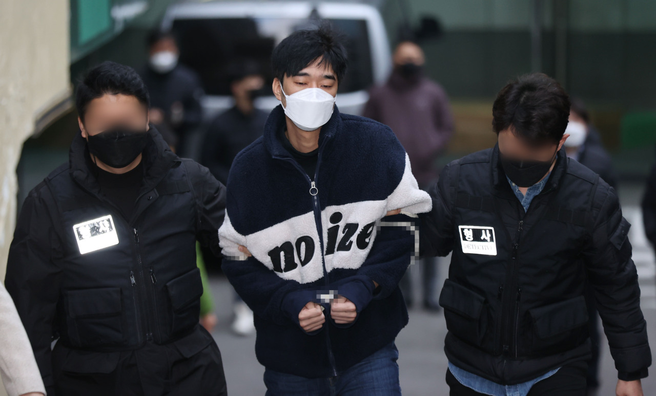 This Nov. 29, 2021, file photo shows Kim Byung-chan, a suspect in a stalking murder case, being escorted from Seoul Namdaemun Police Station to Seoul Central District Prosecutors Office. (Yonhap)