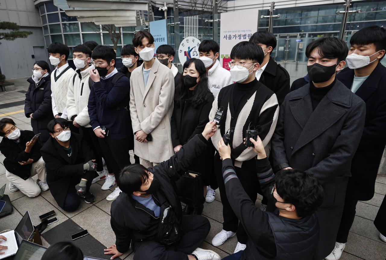 A group of students who filed a lawsuit against the Korea Institute for Curriculum and Evaluation over a disputed bioscience question in this year's college entrance exam hold a press conference at the Seoul Administrative Court on Dec. 10, 2021. (Yonhap)