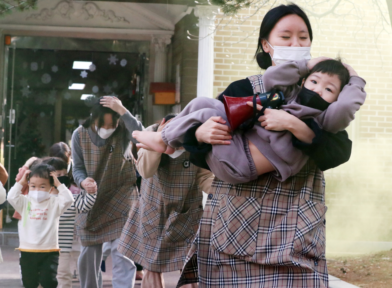 Children and teachers participate in an earthquake drill at a daycare center in Gwangju on Wednedsay, a day after the Jeju quake. (Yonhap)