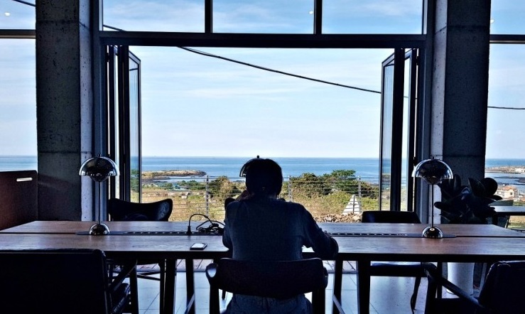 A man looks out to sea while working at O-PEACE JEJU, a co-working site in Jocheon-eup, Jeju Island. (O-PEACE JEJU)