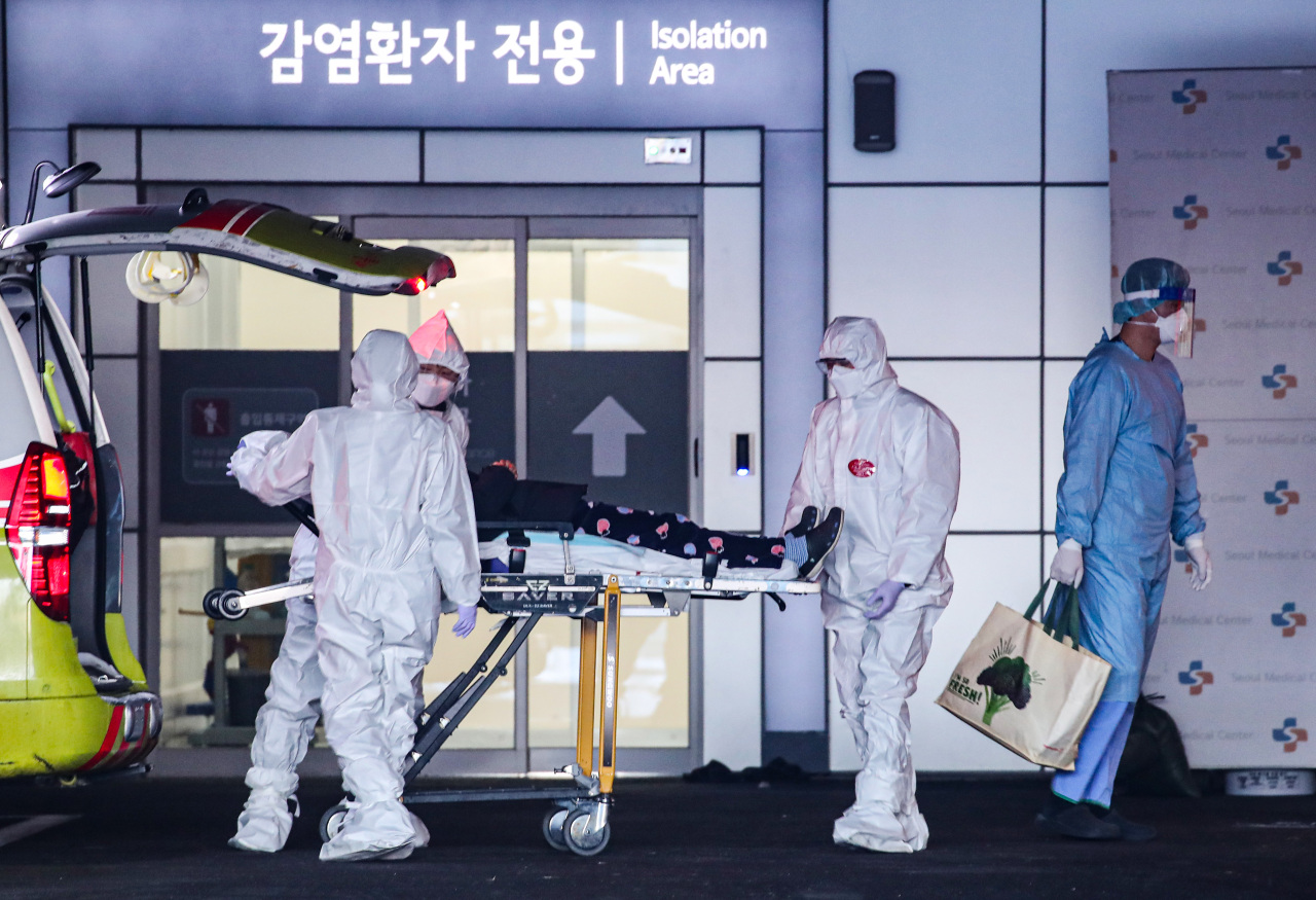 Health care workers transport a COVID-19 patient outside an isolation ward in a public hospital in Seoul. (Yonhap)