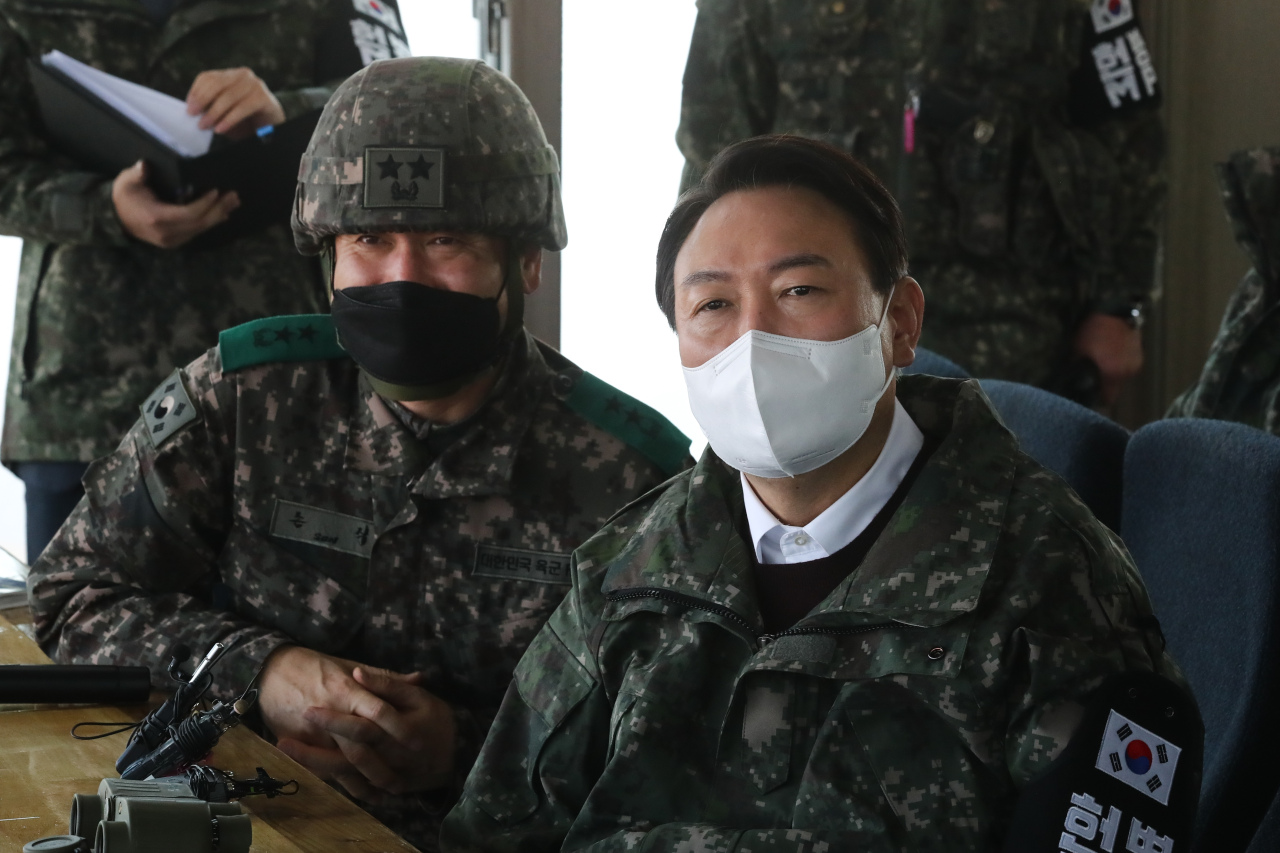 Yoon Suk-yeol (R), the presidential candidate of the main opposition People Power Party, watches a promotional video during his visit to the 3rd Infantry Division in Cheorwon, 88 kilometers north of Seoul, on Monday. (Yonhap)