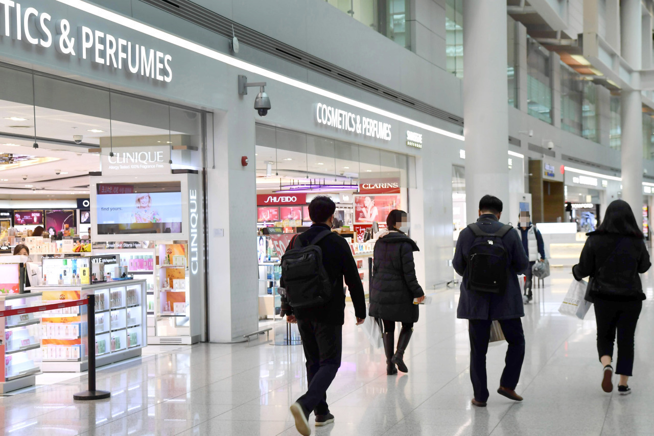 Passengers walk past duty-free stores in Terminal 1 at Incheon Airport. (Yonhap)
