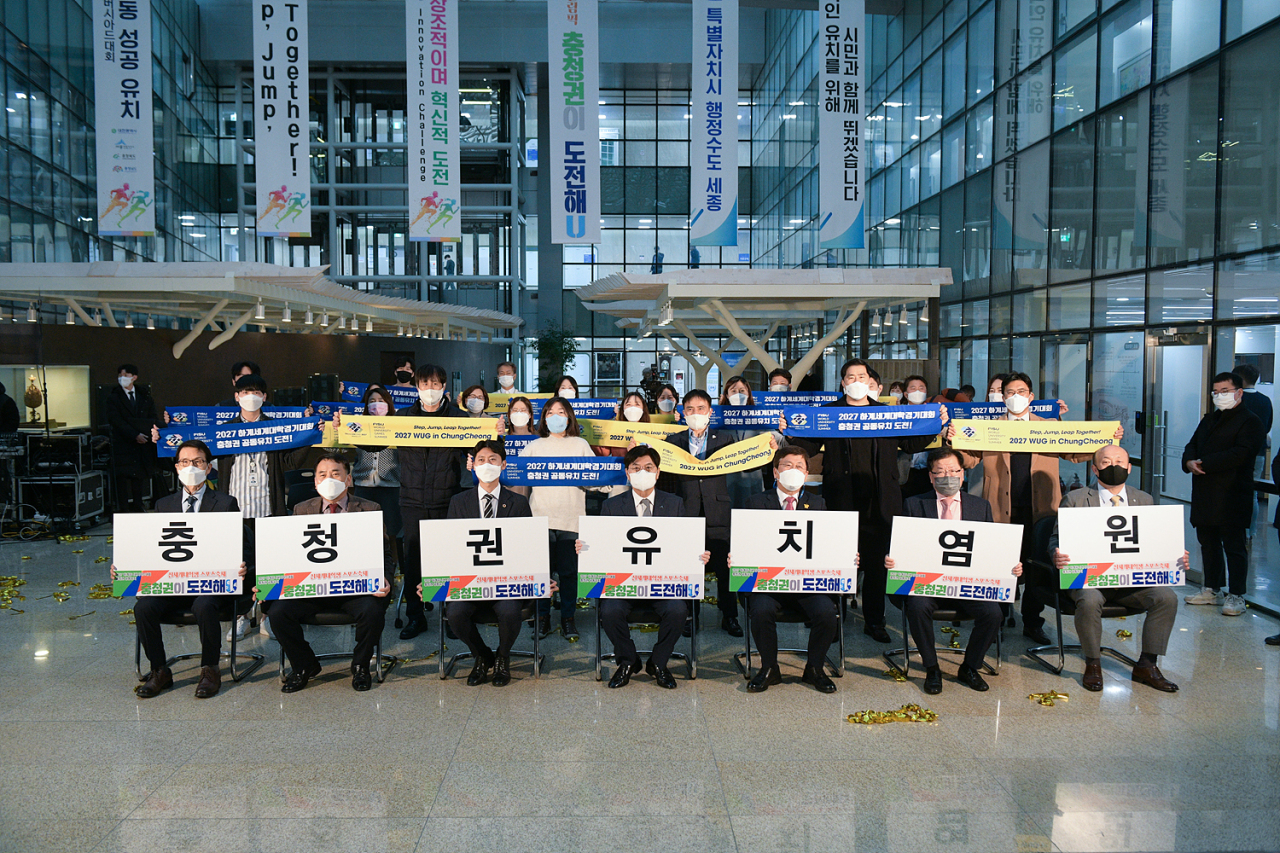 Members of the Chungcheong Megacity Bid Committee hold up signs to promote the Chungcheong area’s bid to host the 2027 Summer World University Games. (Chungcheong Megacity Bid Committee)