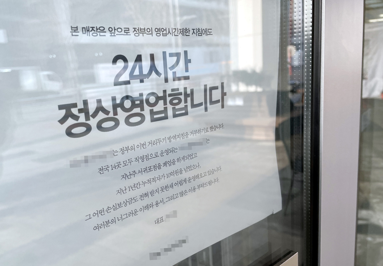 A notice is placed in front of a cafe in Incheon, 40 kilometers west of Seoul, on Tuesday, announcing its plans to remain open 24 hours in defiance of government-mandated COVID-19 business curfews. (Yonhap)