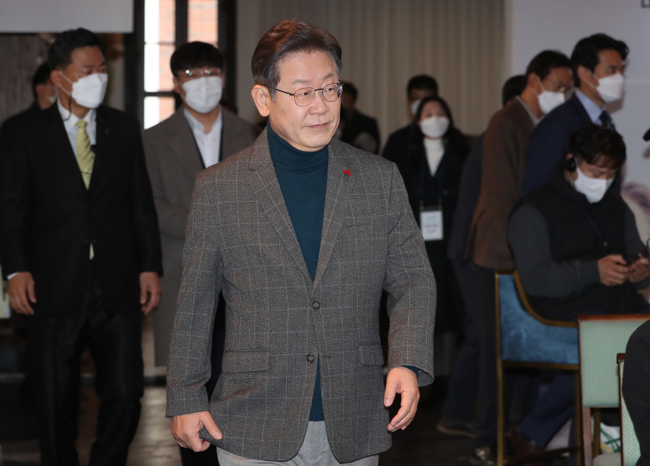 Lee Jae-myung, the presidential candidate of the ruling Democratic Party, enters a meeting room to have an online conversation with American political philosopher Michael Sandel over the future of South Korea at an arts center in Seoul on Tuesday. (Yonhap)