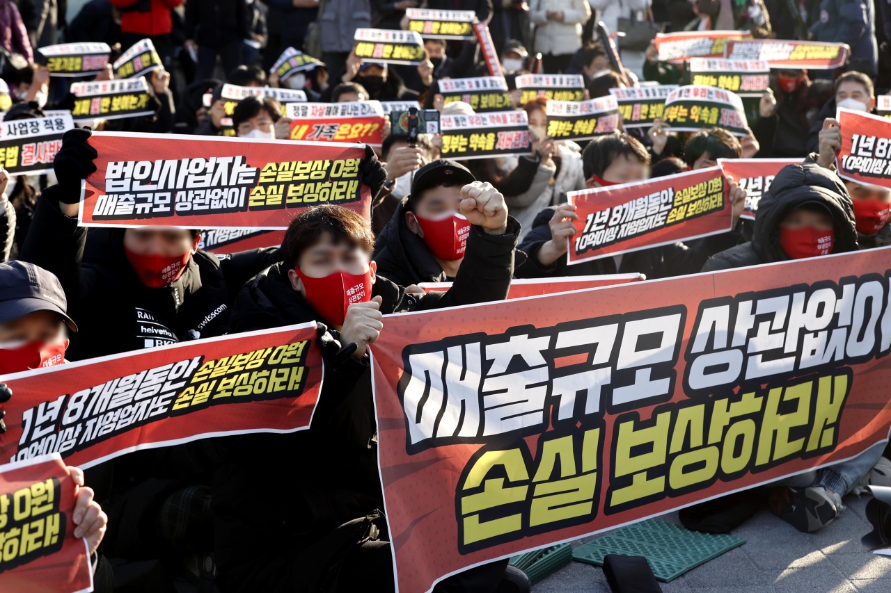Small business owners stage a sit-in protest Wednesday in Gwanghwamun, central Seoul, Wednesday. (Yonhap)