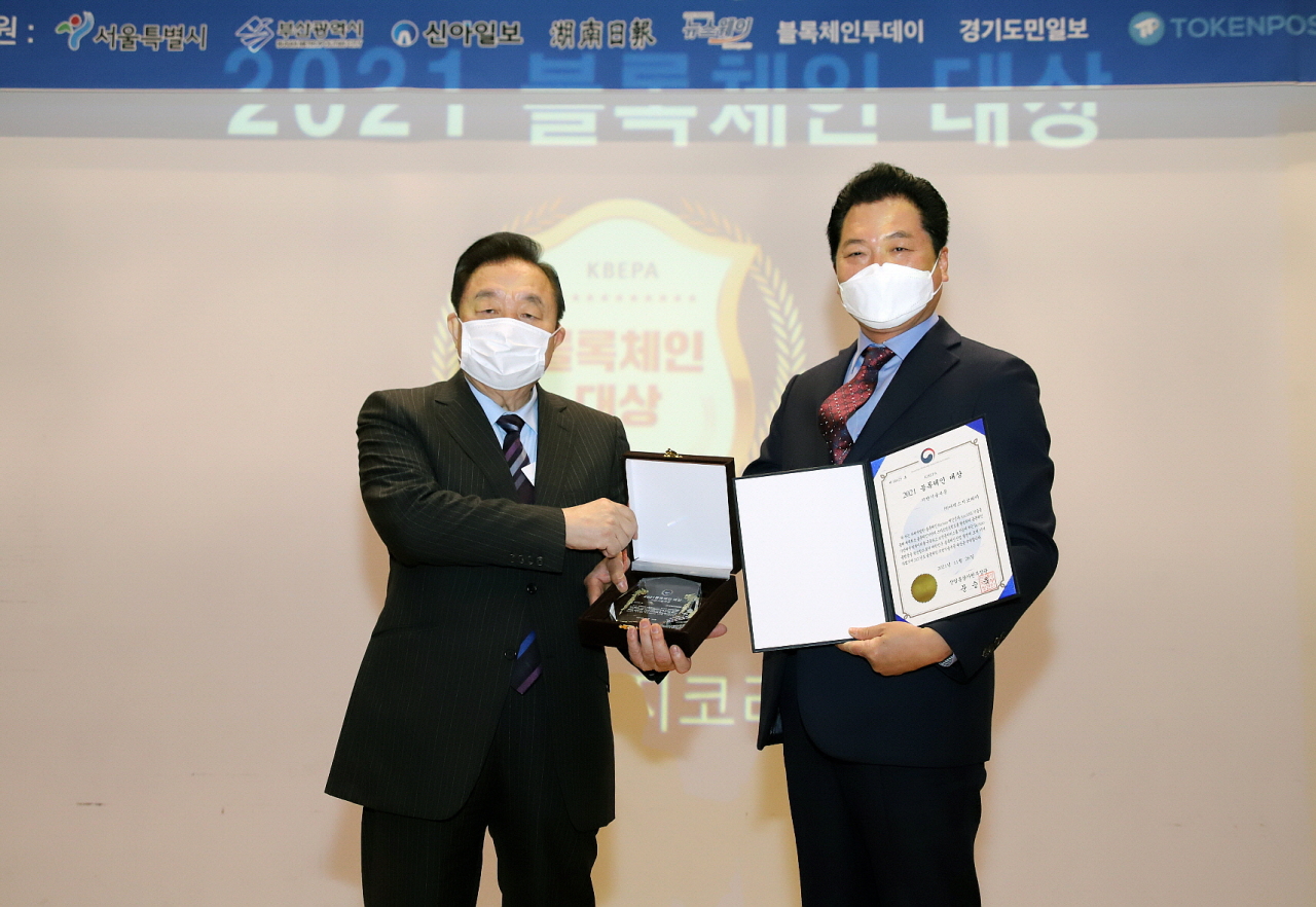AMAXG Group chief executive Choi Jeong-moo (right) poses for a photo after receiving a ministerial award at the 2021 Blockchain Awards organized by the Korea Blockchain Enterprise Promotion Association on Nov. 26.