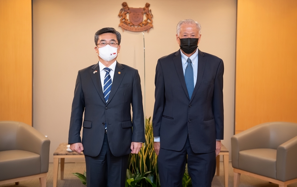 South Korea's Defense Minister Suh Wook (left) poses for a photo with Singaporean Defense Minister Ng Eng Hen in Singapore on Dec. 23, 2021, in this photo released by the Ministry of National Defense. (Yonhap)
