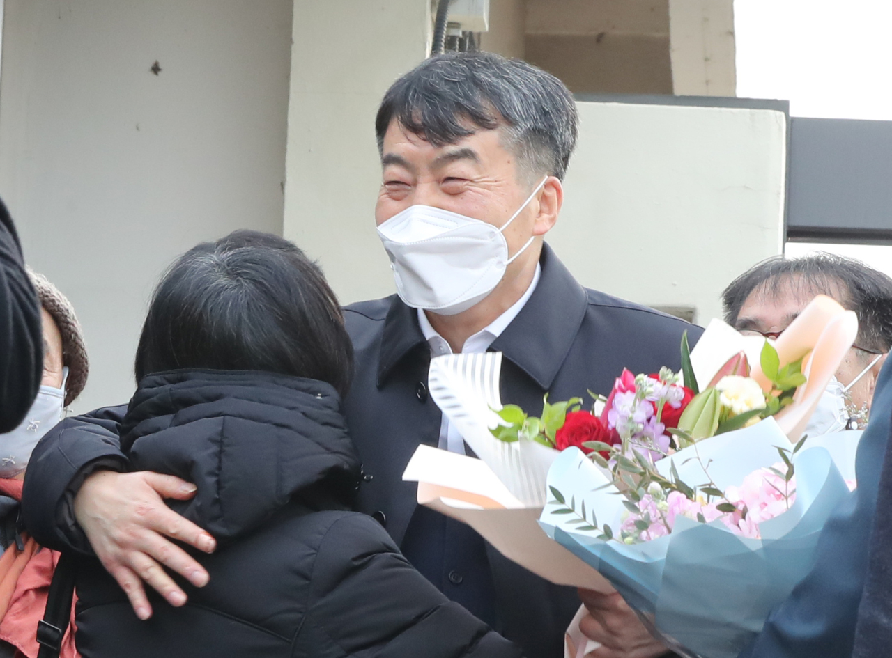 Lee Seok-ki, a former left-wing lawmker who had been sent to prison on charges of plotting a rebellion to overthrow the South Korean government in case of a war with North Korea, hugs one of his supporters after being released from a prison in the central city of Daejeon on parole on Dec. 24, 2021. (Yonhap)