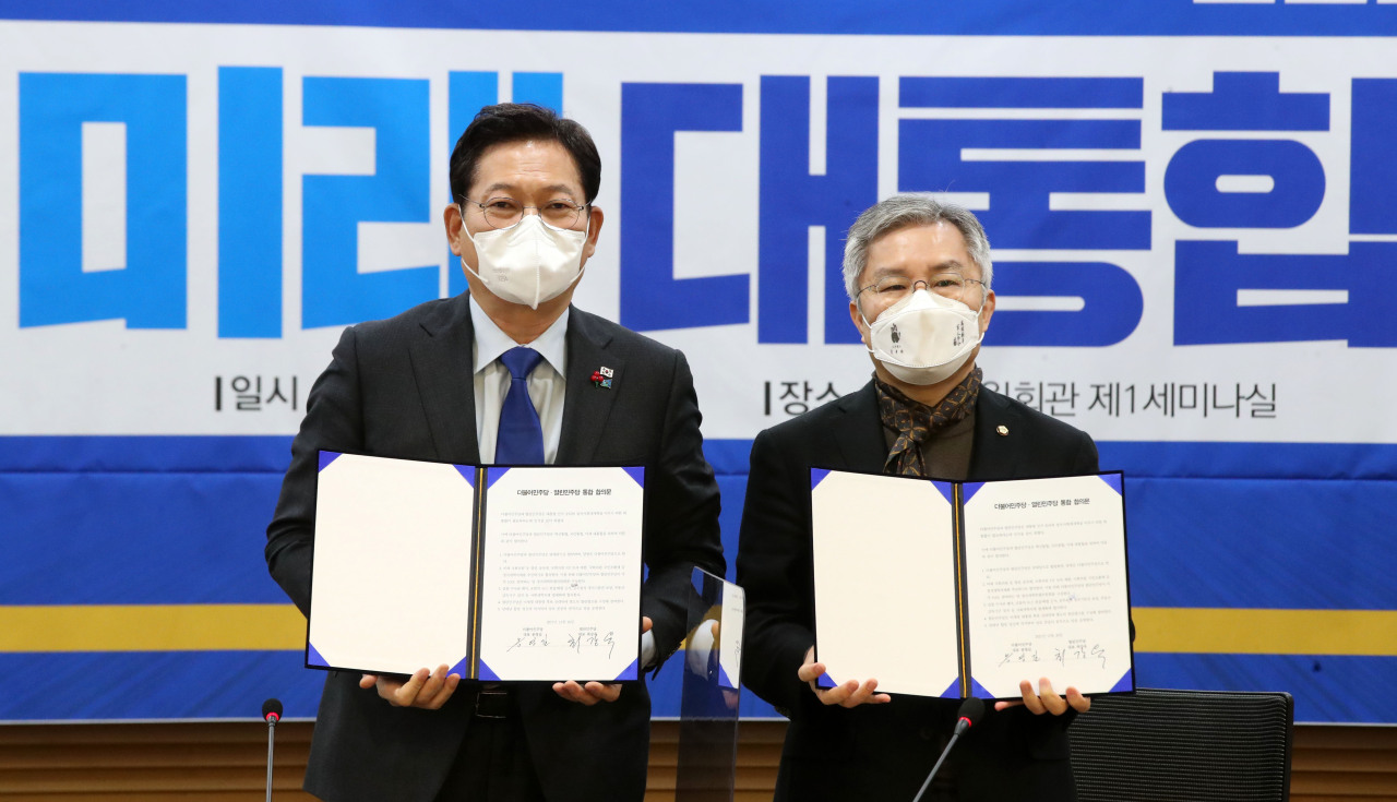Ruling Democratic Party leader Song Young-gil and Choe Kang-wook, the head of the splinter minor Open Democratic Party, announce their parties' merger agreement at the National Assembly in Seoul on Sunday.