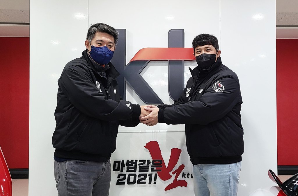 KT Wiz infielder Hwang Jae-gyun (R) shakes hands with the club's general manager, Lee Soong-yong, on Monday, after signing a new four-year contract to stay put with the Korea Baseball Organization club, in this photo provided by the Wiz. (KT WIz)