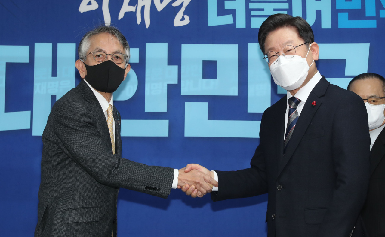 Lee Jae-myung (R), the presidential nominee of the ruling Democratic Party, shakes hands with Japanese Ambassador to Seoul Koichi Aiboshi at their meeting at the party's headquarters in Seoul on Monday. (Yonhap)