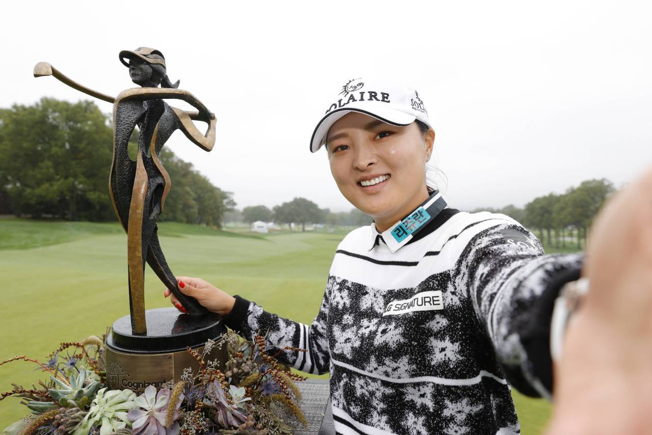 In this Getty Images photo, Ko Jin-young of South Korea imitates taking a selfie with the champion's trophy after winning the Cognizant Founders Cup at Mountain Ridge Country Club in West Caldwell, New Jersey, on Oct. 10. (Getty Images)