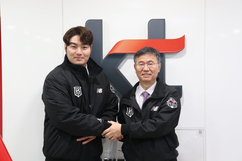 New KT Wiz infielder Park Byung-ho (L) shakes hands with the club CEO Nam Sang-bong after signing a three-year contract with the Korea Baseball Organization team on Wednesday, in this photo provided by the Wiz. (Wiz)