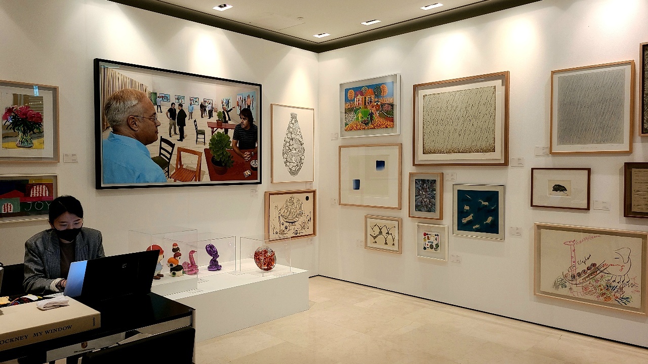 A curator works next to artworks displayed at Shinsegae Department Store’s “Blossom Art Fair” at the department store’s Myeong-dong branch in October. (The Korea Herald/Kang Jae-eun)