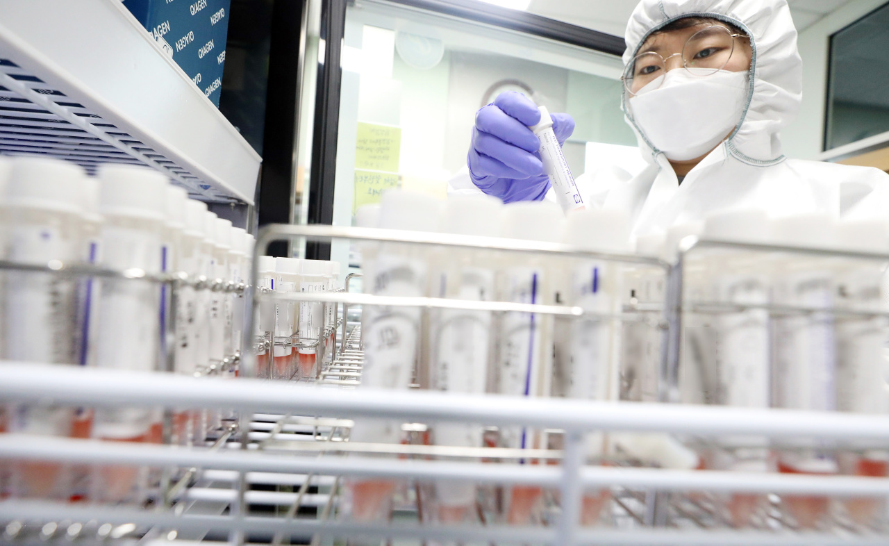 A researcher inspects samples to be tested for the omicron variant at a lab in Sejong, south of Seoul, on Thursday. (Yonhap)