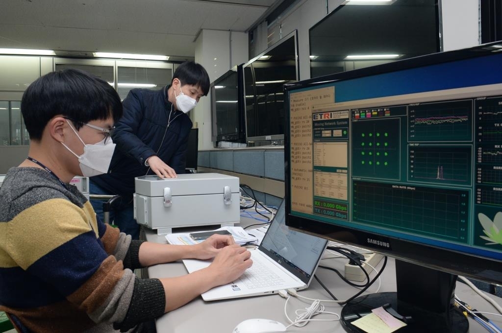 This photo provided by the Electronics and Telecommunications Research Institute (ETRI) on Thursday, shows researchers conducting a check of the newly developed 5G-satellite multiple network system. (ETRI)