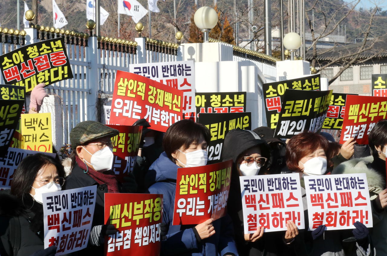 Members of a Seoul-based parents group stage a rally in southern Seoul protesting the government‘s plan to expand the COVID-19 vaccine pass program to teenagers on Dec. 11, 2021. (Yonhap)