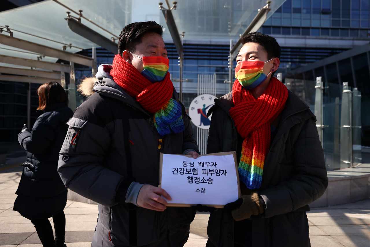 So Seong-wook (L) and Kim Yong-min, a South Korean gay couple, stand in front of the Seoul Administrative Court in southern Seoul on Feb. 19, 2021, before filing an administrative lawsuit against the National Health Insurance Service. (Yonhap)