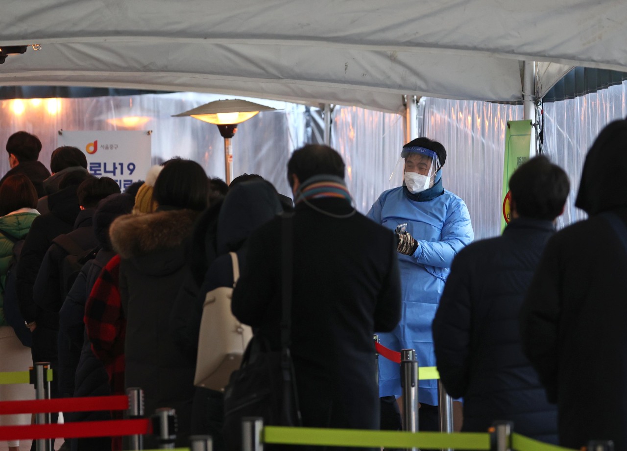 Citizens wait in line to receive COVID-19 tests at a makeshift clinic in central Seoul on Friday. (Yonhap)