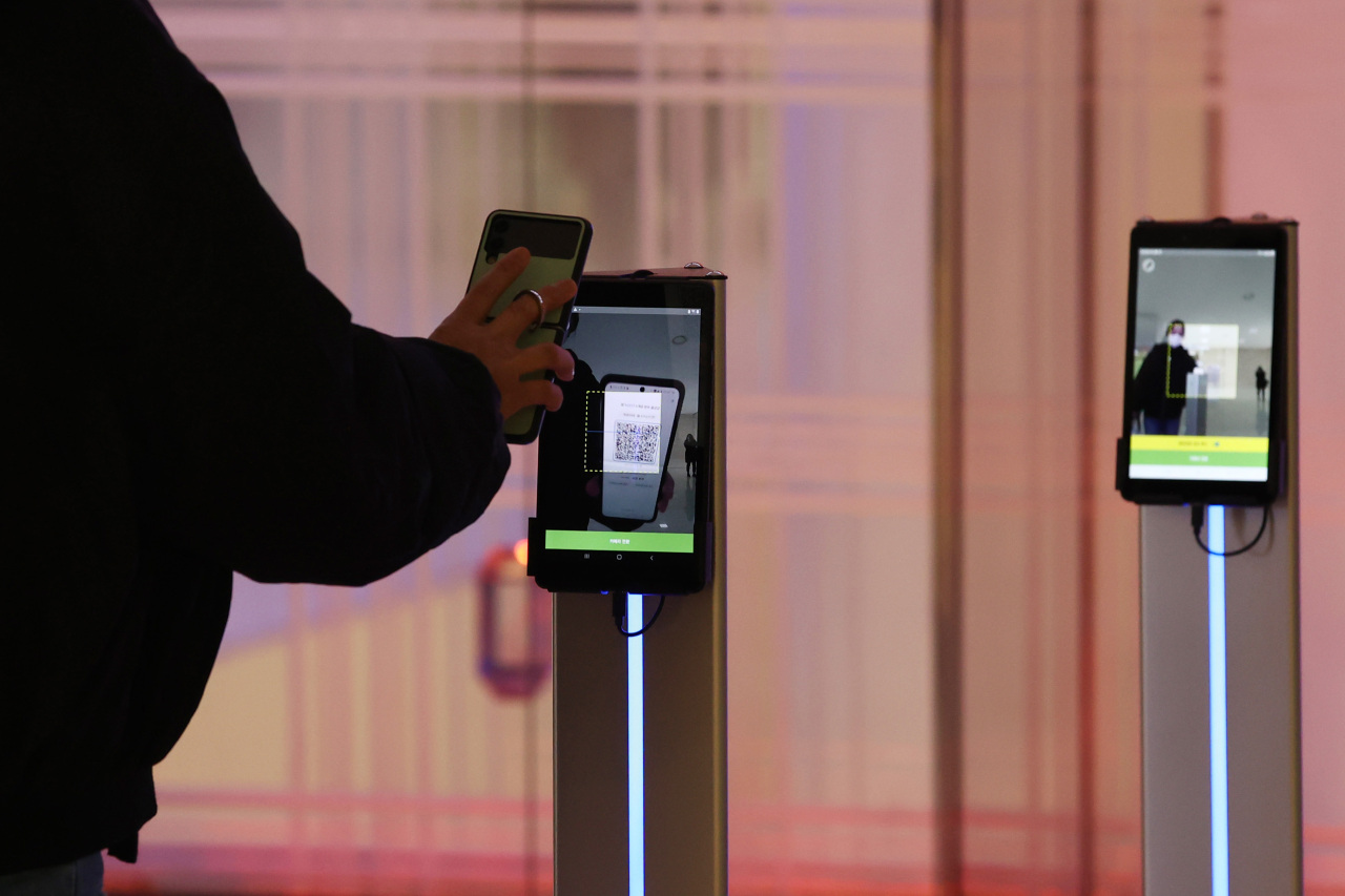 QR code scanners are set up at the entrance of a mall in Seoul. Visitors must scan their personal QR code generated through a smartphone app before entering. (Yonhap)