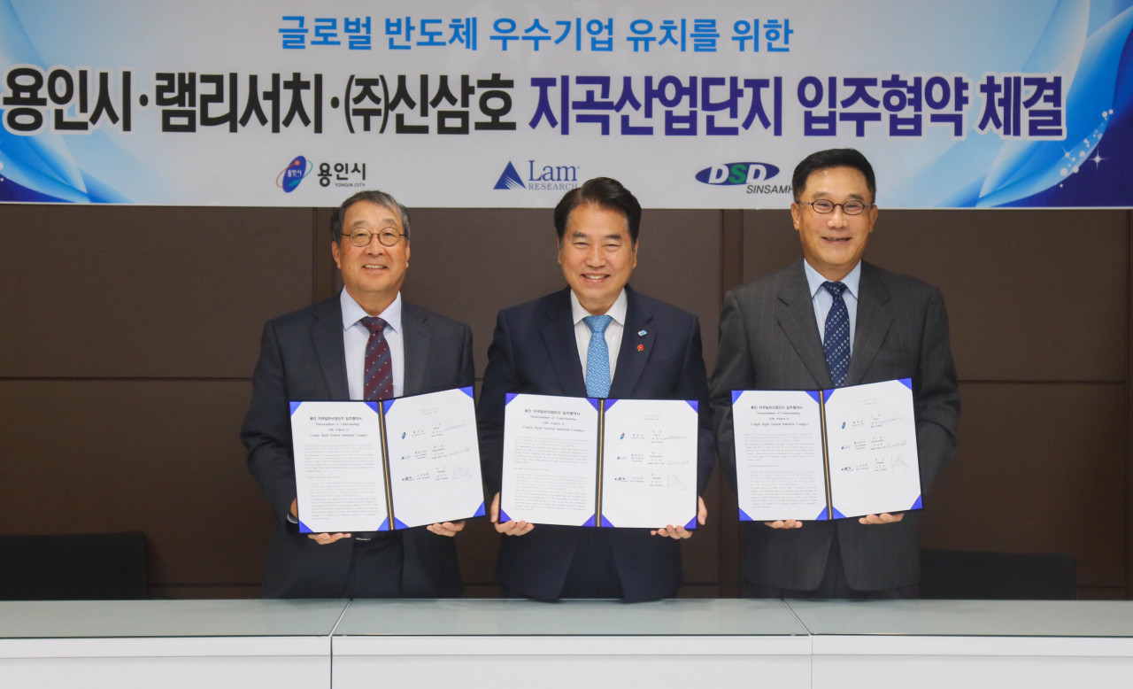 Yongin Mayor Baek Kun-ki (center) holds up the agreement signed with Lam Research to provide an industrial site to establish a technology center in Nov. 2019.