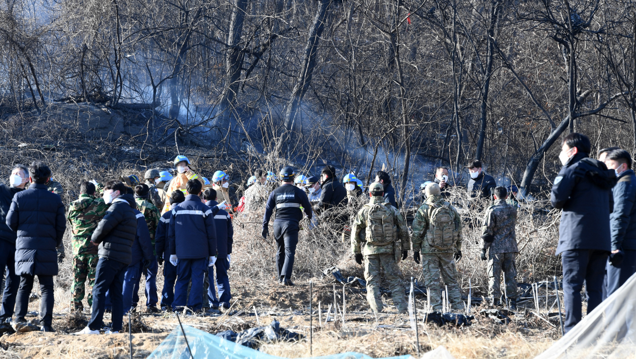 Military officials check the wreckage of an F-5E fighter on a hill in Hwaseong, about 40 kilometers south of Seoul, where the plane belonging to the Air Force's 10th Combat Squadron crashed shortly after takeoff at 1:44 p.m. on Tuesday. (Yonhap)