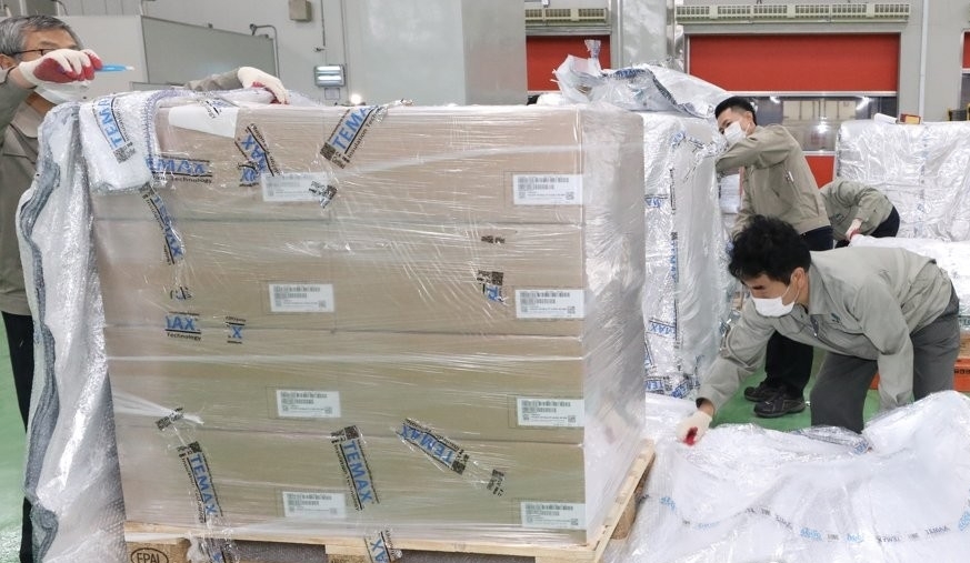Workers at a distribution center in the central county of Ochang open boxes containing Paxlovid, COVID-19 treatment pills developed by U.S. pharmaceutical giant Pfizer Inc., on Jan. 13, 2022. The first batch of Paxlovid for 21,000 people arrived in South Korea earlier in the day. (Yonhap)