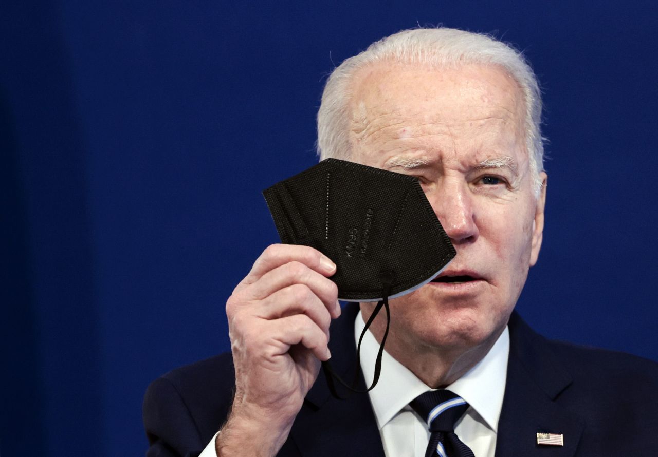 US President Joe Biden holds a mask on Jan. 13 in Washington, DC. as he gives remarks on his administration`s plan to make 