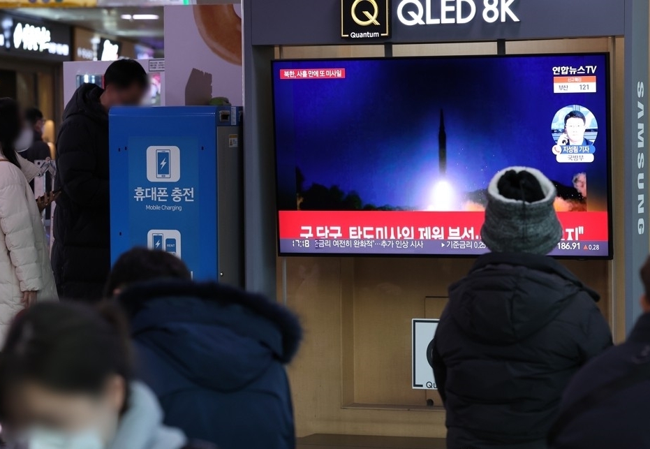 This photo, taken on Jan. 14, 2022, shows people watching a media report on a North Korean missile launch at Seoul Station in Seoul. (Yonhap)