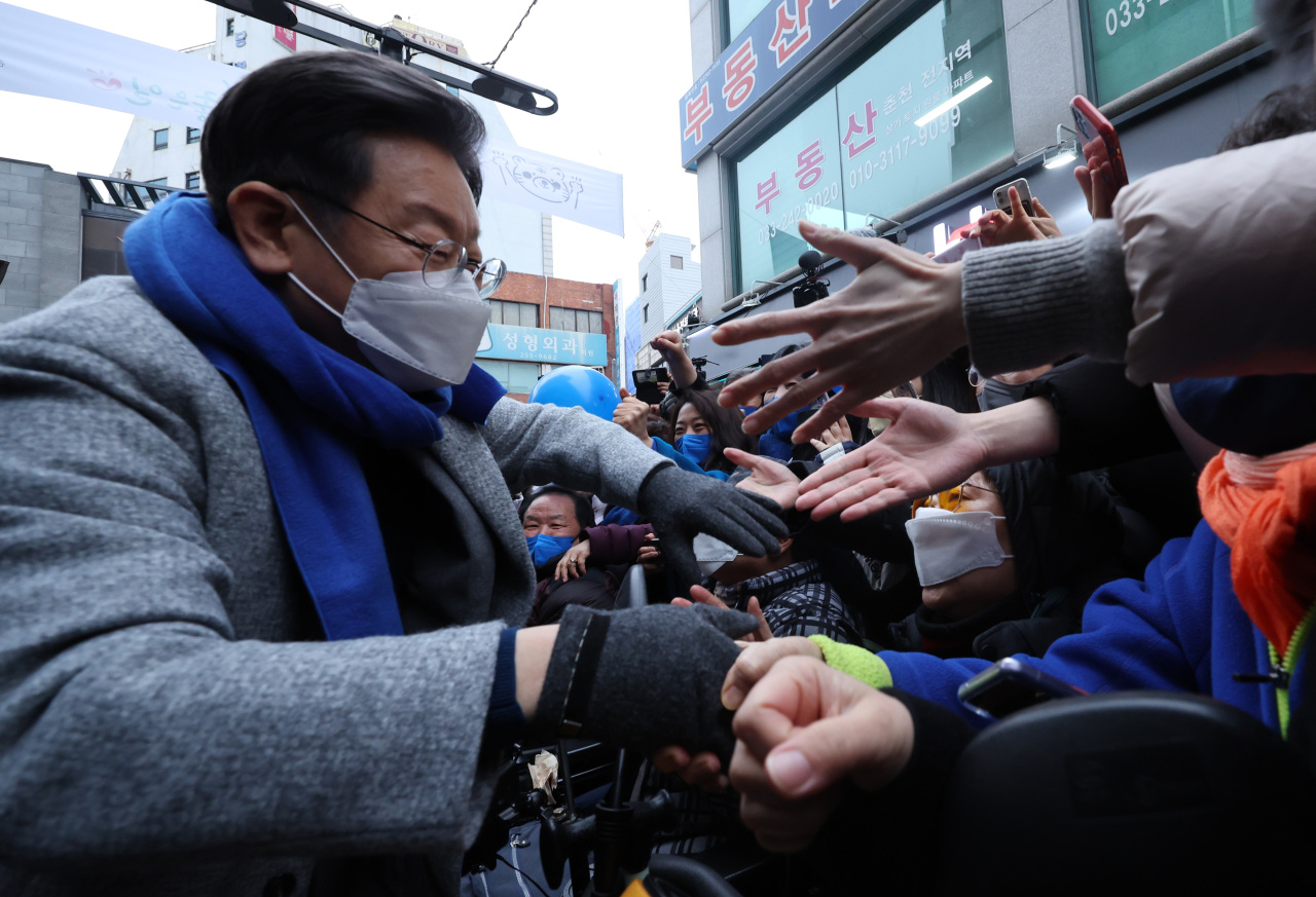 Lee Jae-myung, the presidential nominee of the Democratic Party, greets citizens in Chuncheon, Gangwon Province, on Saturday. (Yonhap)