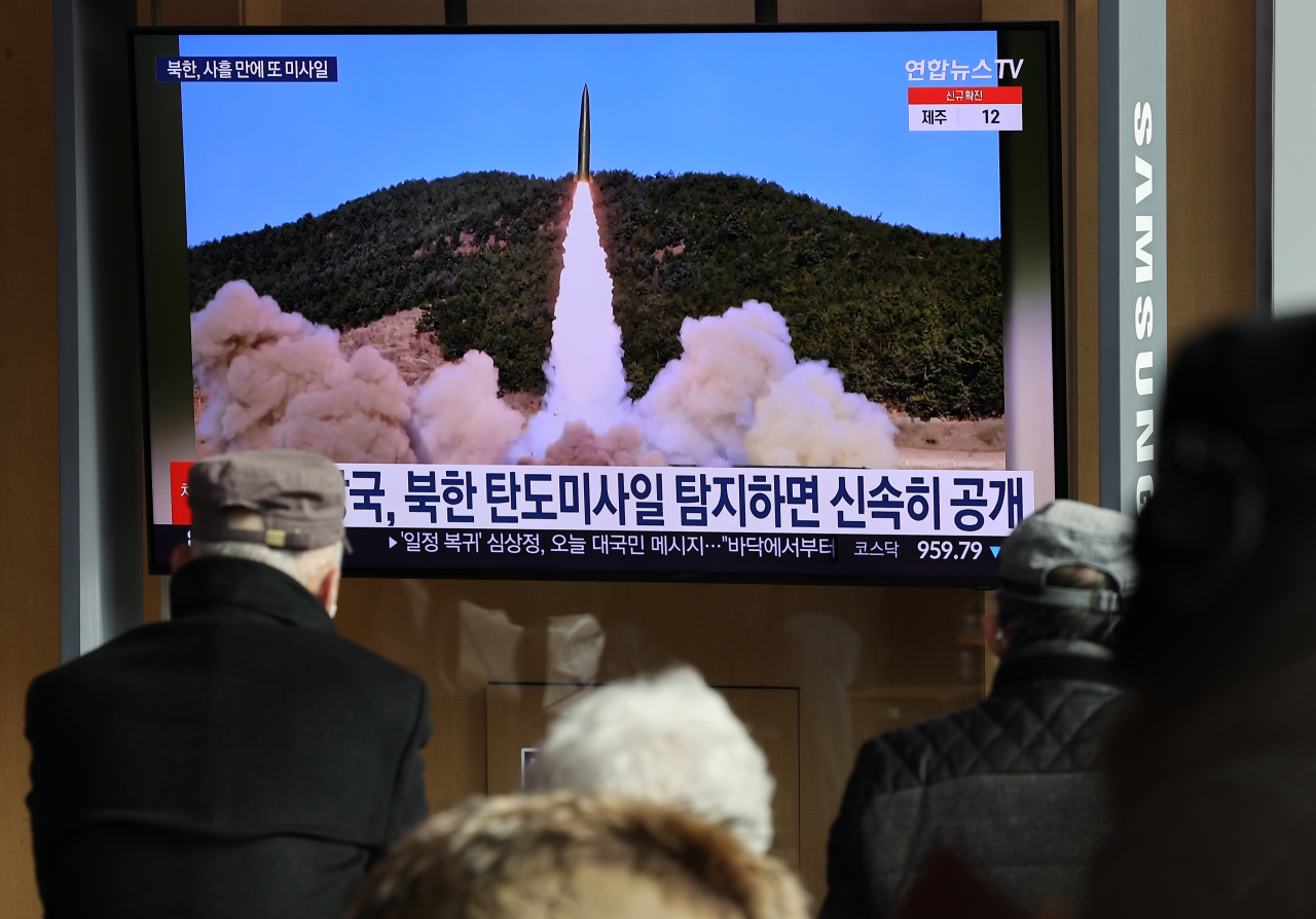 Passersby watch a TV report of North Korea’s missile launch at Seoul Station on Monday. (Yonhap)