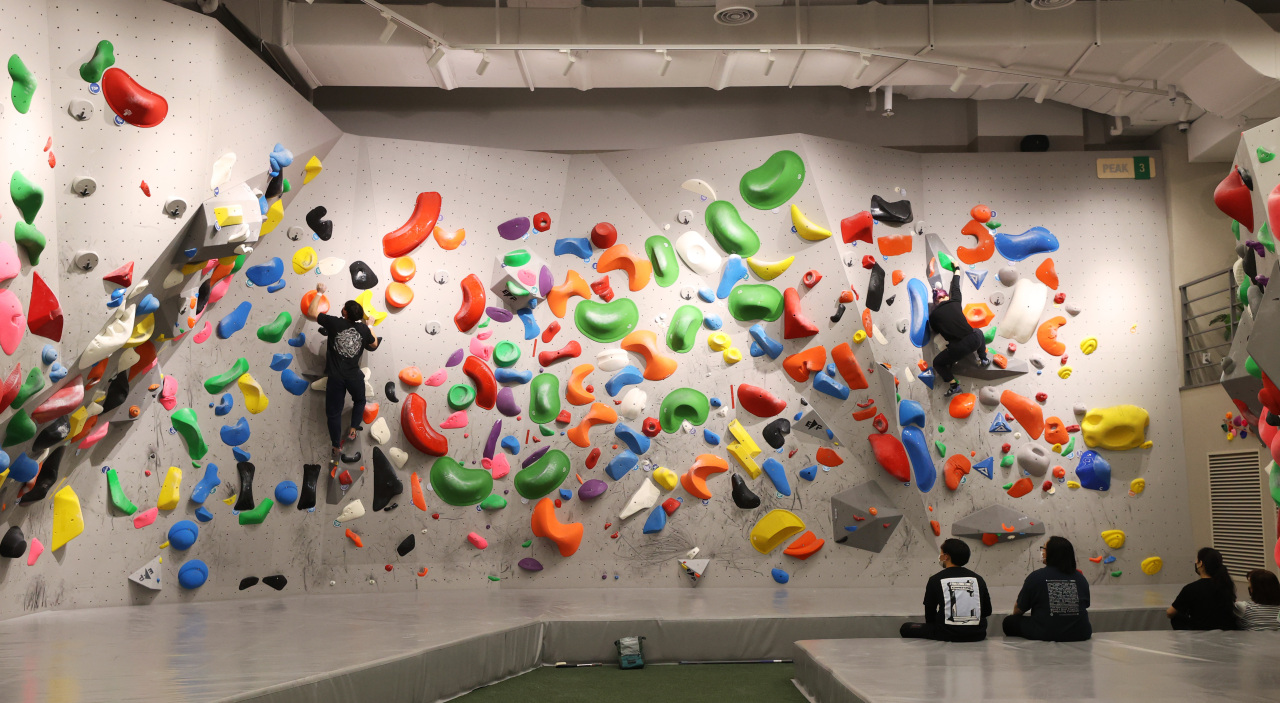 Visitors try a climbing wall at Peakers in CGV Piccadilly 1958 in Jongno, Seoul, on Jan. 13. (Yonhap)