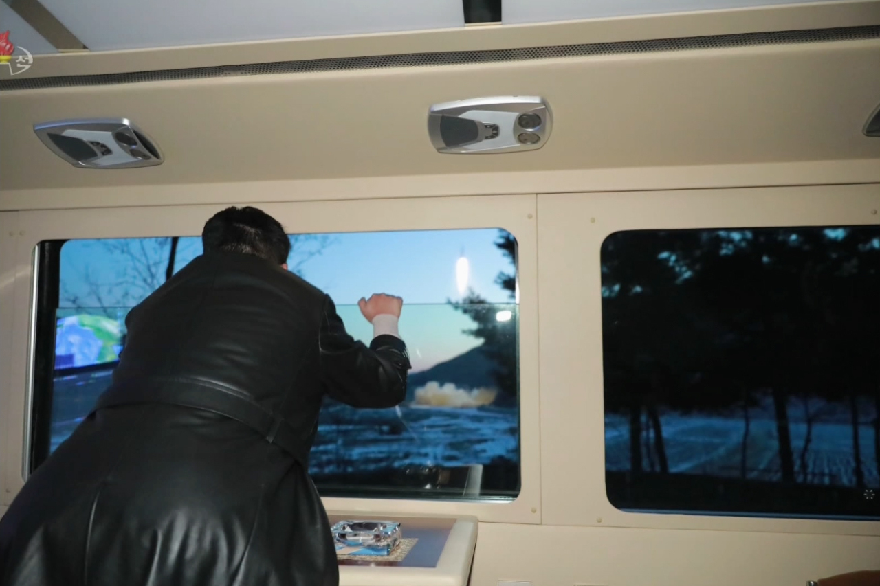 This photo, captured from North Korea's official Korean Central Television last Wednesday, shows North Korean leader Kim Jong-un watching the firing of what the country claims to be a new hypersonic missile from a car the previous day. (KNCA-Yonhap)