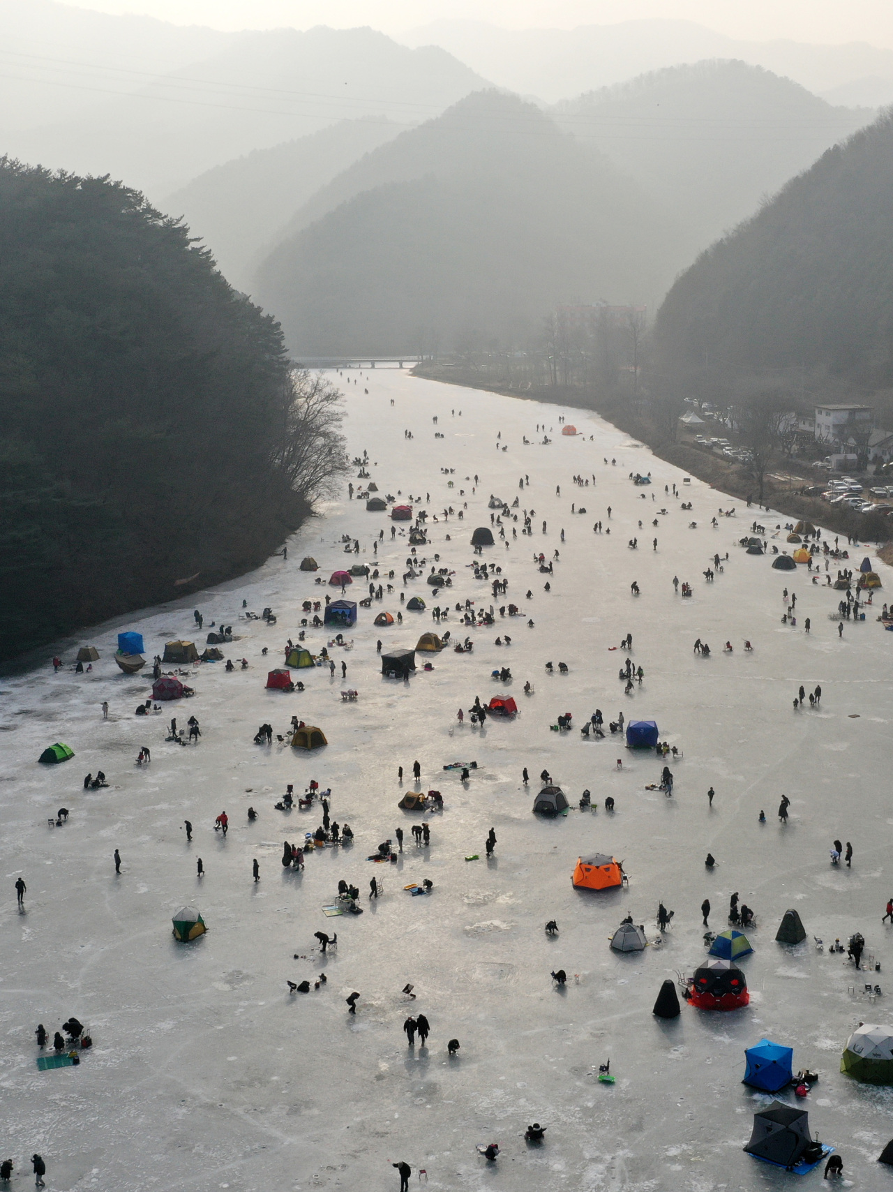 An ice fishing site at Owolli in Chuncheon, Gangwon Province, is packed with visitors catching trout. (Yonhap)