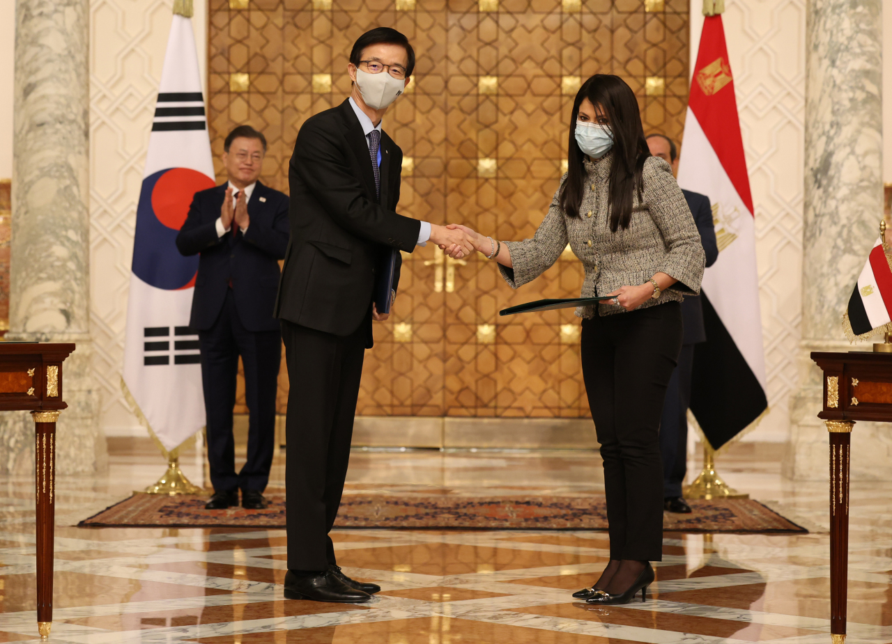 This photo, taken Thursday, shows Bang Moon-Kyu (L), chief of the state-run Export-Import Bank of Korea (Exim Bank), shaking hands with Rania A. Al-Mashat, Egypt's international cooperation minister, after they clinched a memorandum of understanding over the 2022-26 Economic Development Cooperation Fund. (Yonhap)